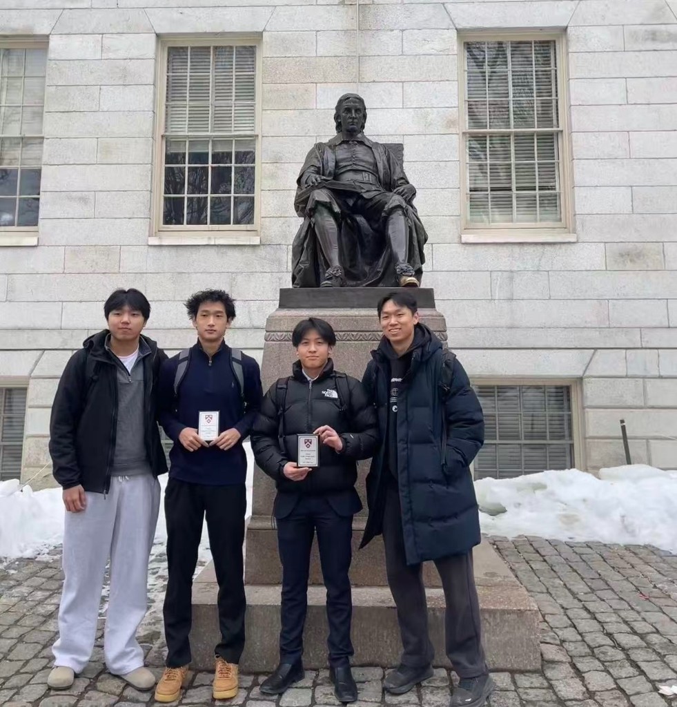 Students with debate awards at the John Harvard statue, Harvard University