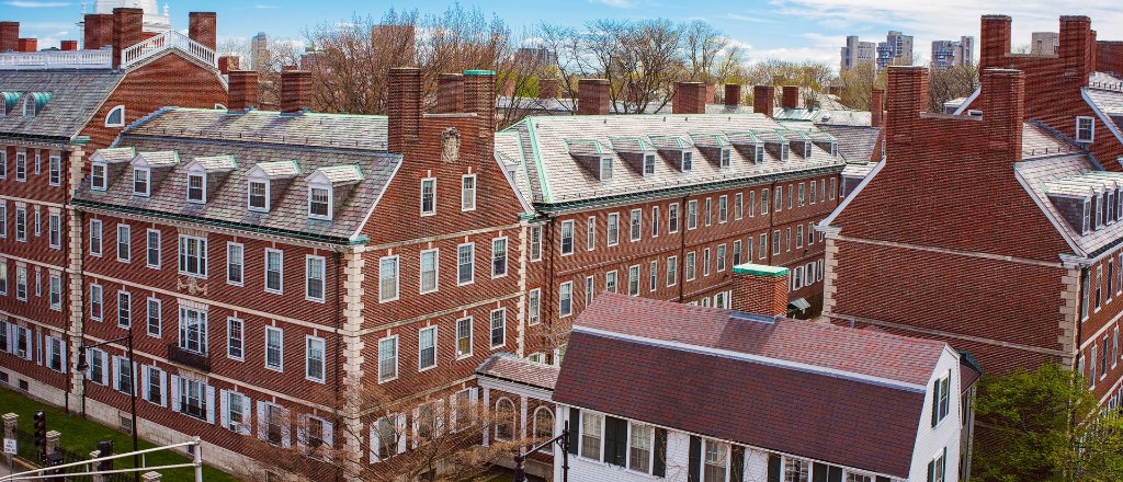 Panoramic view of red brick university campus buildings with slate roofs and chimneys